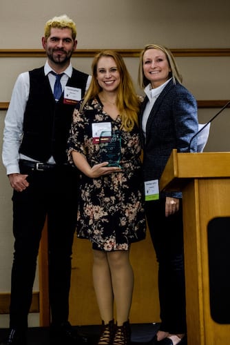 Picture of echo greenlee with representatives from 5th Ave Theater