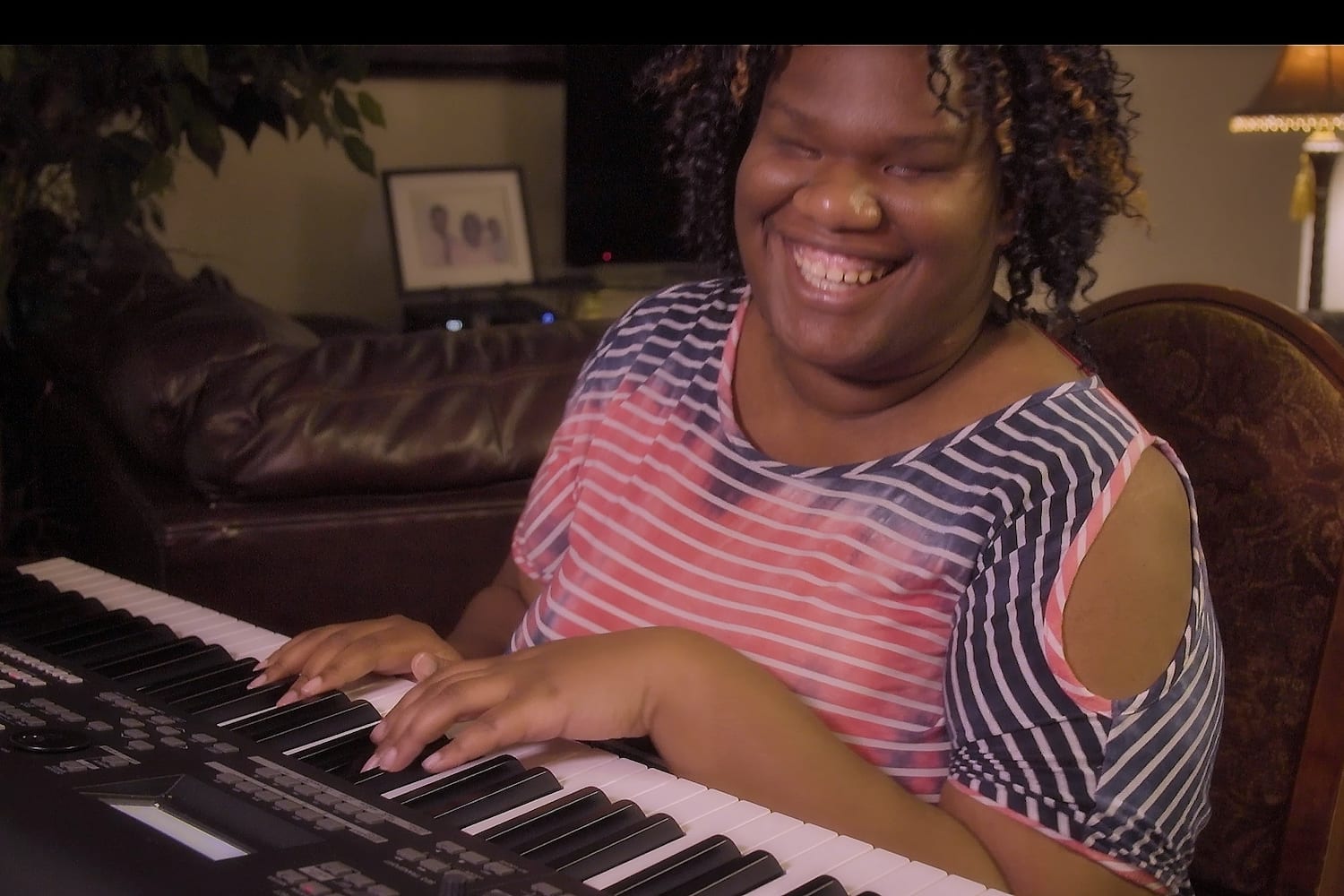 Photo of Alexandria playing the piano, a NWAF loan helped pay for her BrailleNote Touch