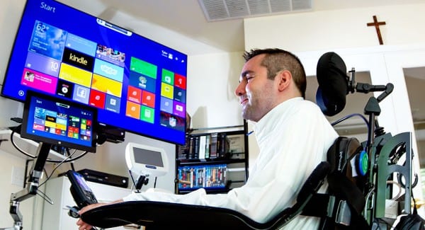 Tyler sitting at his computer and desk in his home office.