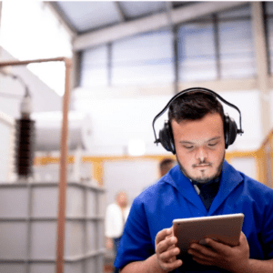 Young man in a blue shirt wearing headphones and looking at a tablet